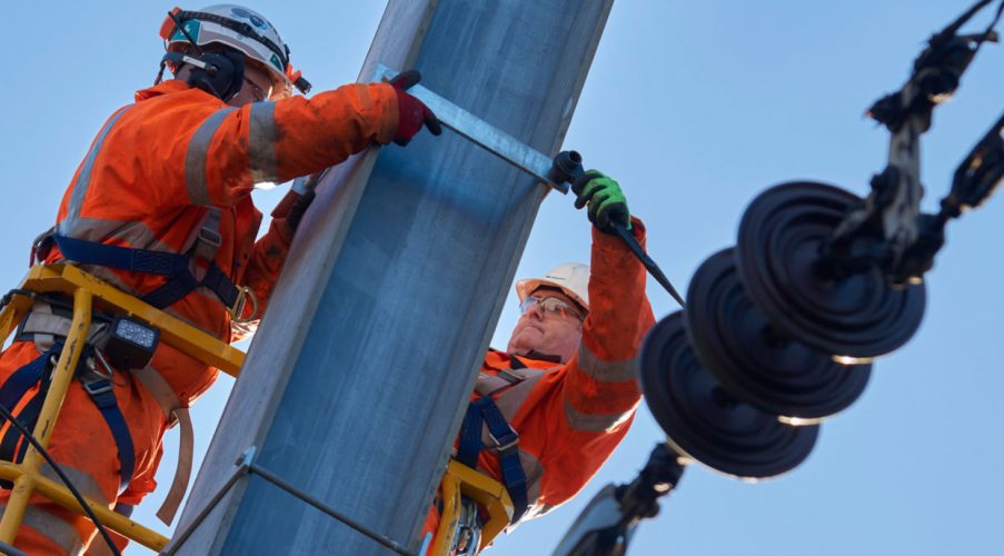 Two engineers working to upgrade the power supply on the East Coast Mainline