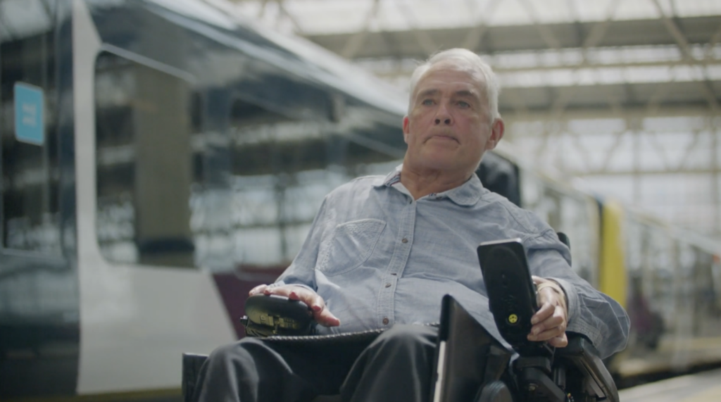 亚搏彩票软件官网网络铁路董事会成员斯蒂芬·达克沃斯与一辆火车在火车站平台背景。